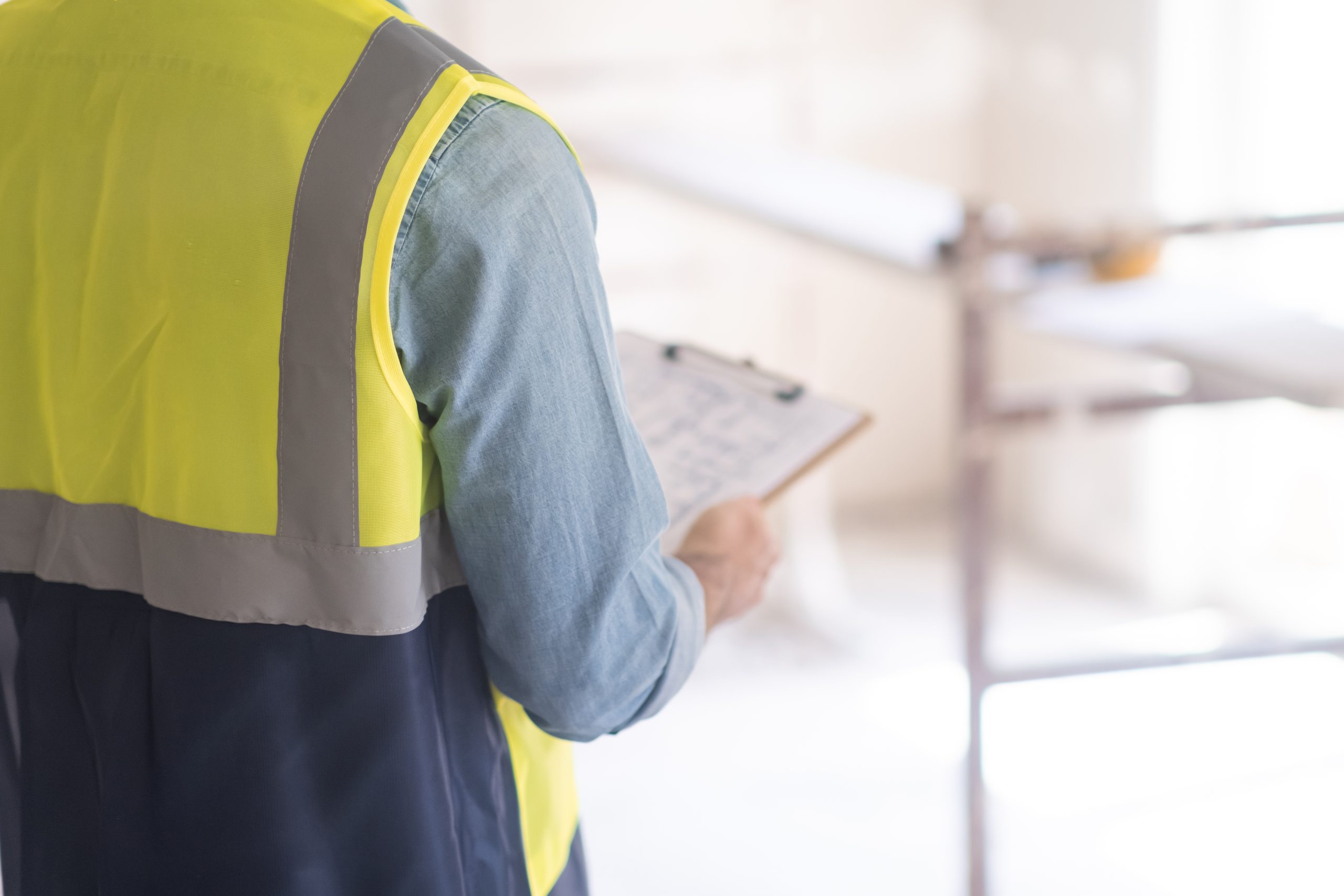 עובד בחליפת ביטחון בודק היתר בניה